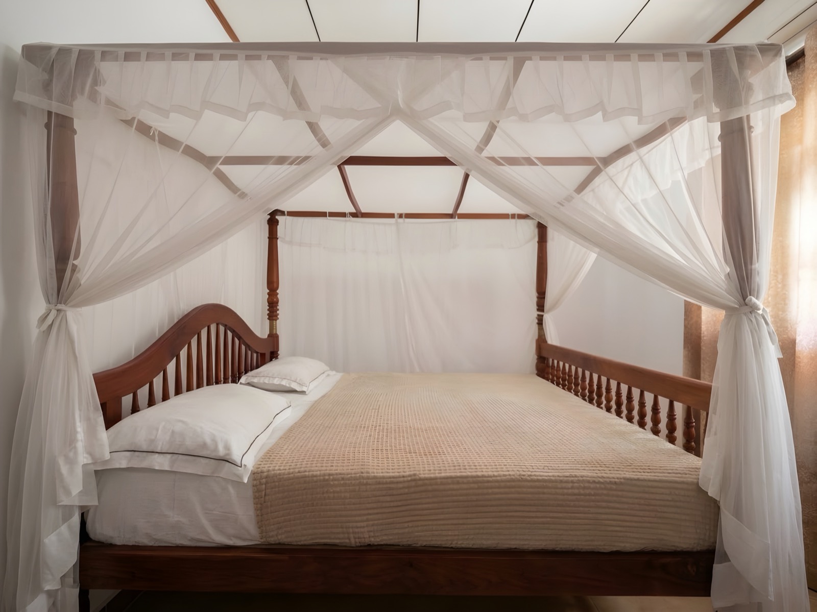 Double room with a carved four-poster bed and mosquito net